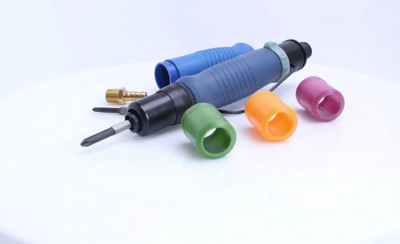 Straight pneumatic screwdriver on white surface with colored plastic caps and brass air fitting, blue grip visible.