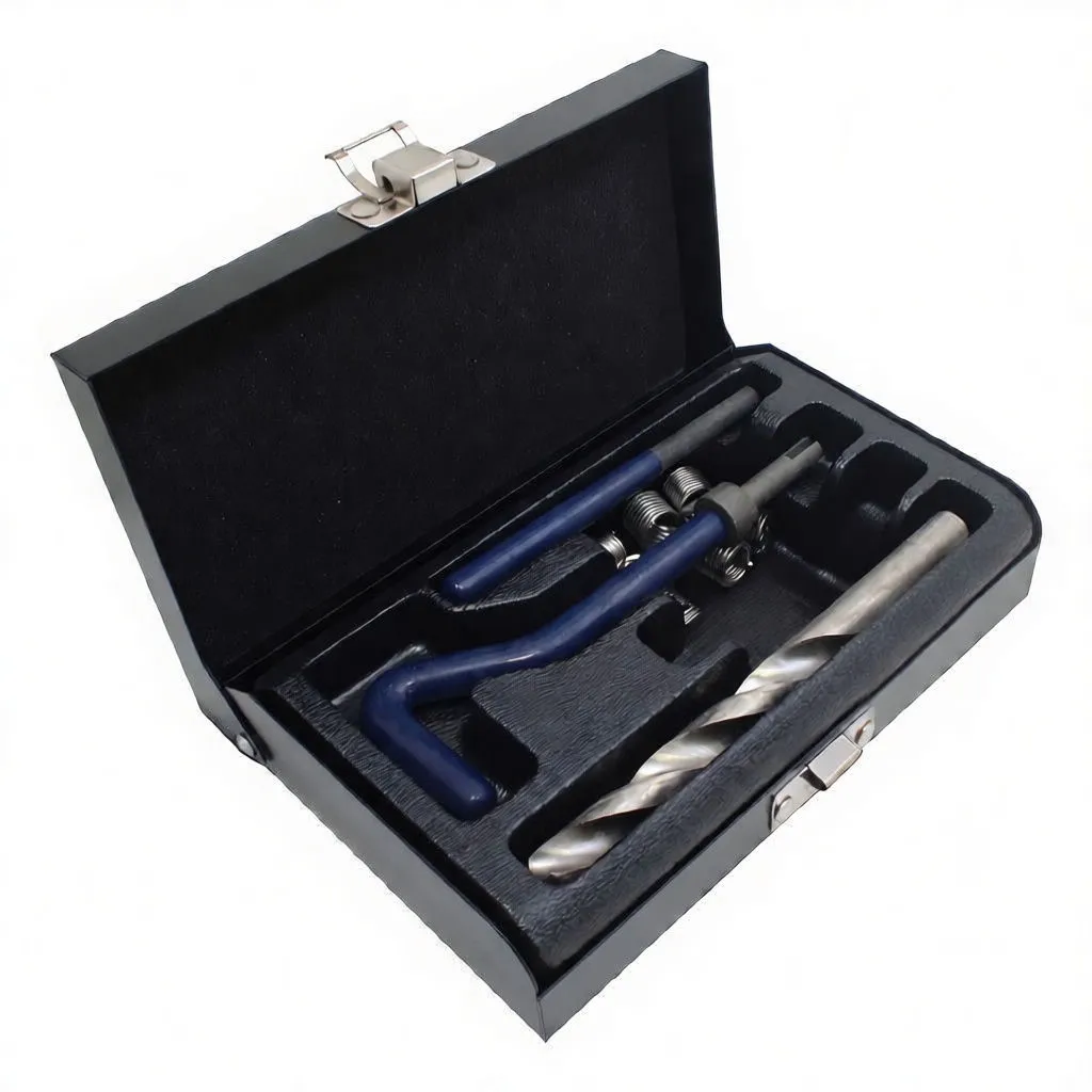 Angled shot of open thread repair kit with blue tools, drill bit, tap and helicoil inserts in foam-lined metal case