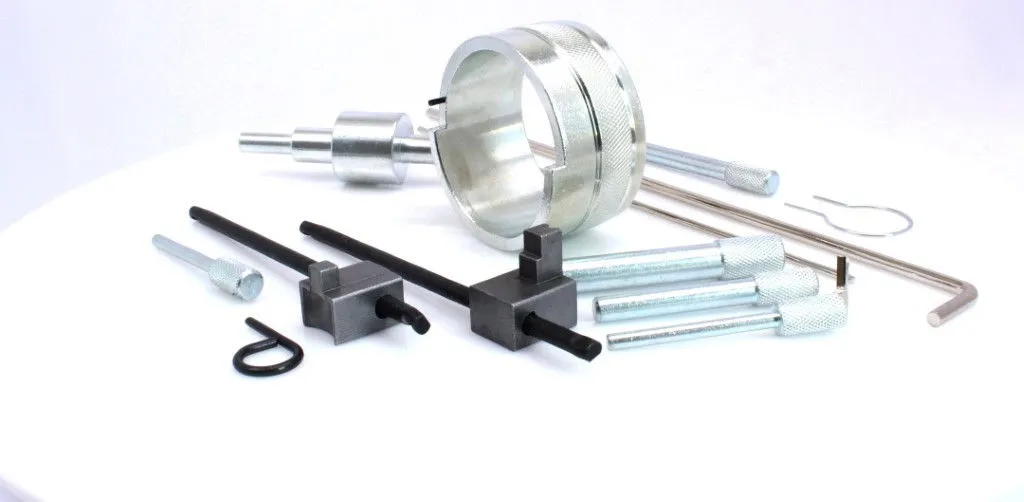 Timing kit components on white background: circular sleeve, adapter, black locating bars, knurled pins and rods.