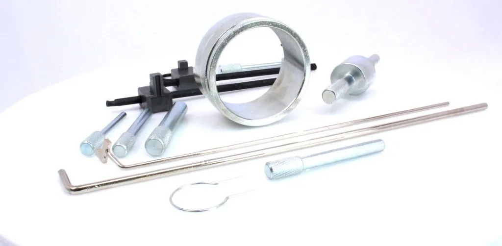 Close-up of timing belt kit pieces: circular sleeve, adapter, long rods, knurled driver, black locating bars and clip.