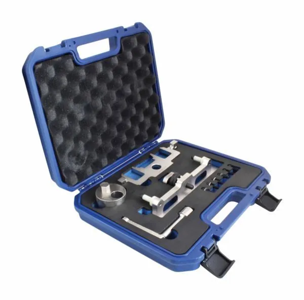 Angled open case holding timing chain guide tools: machined metal alignment bracket with white spacers, circular cup tool, L-wrench and six black pins in foam.