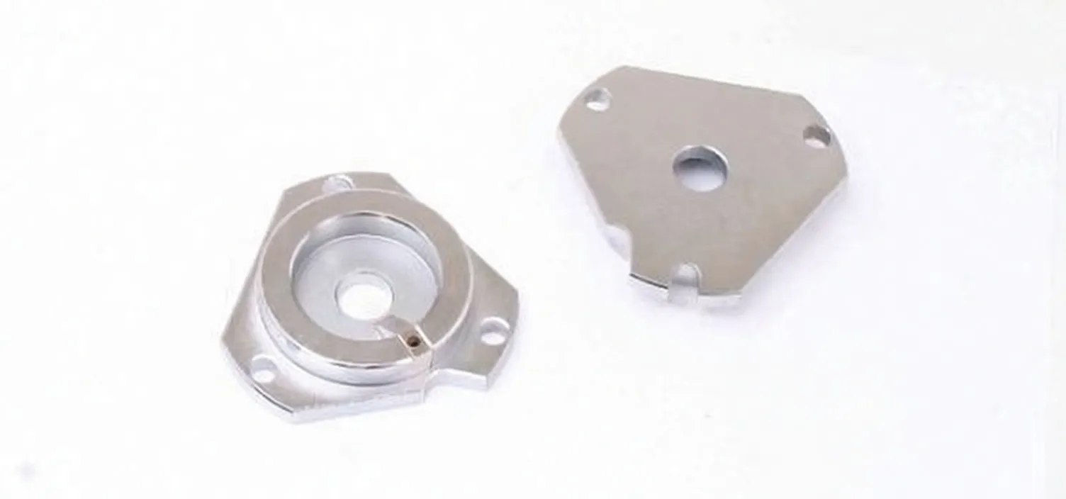 Two silver machined locking plates, one cup-shaped and one flat triangular, with central holes and brand stamp