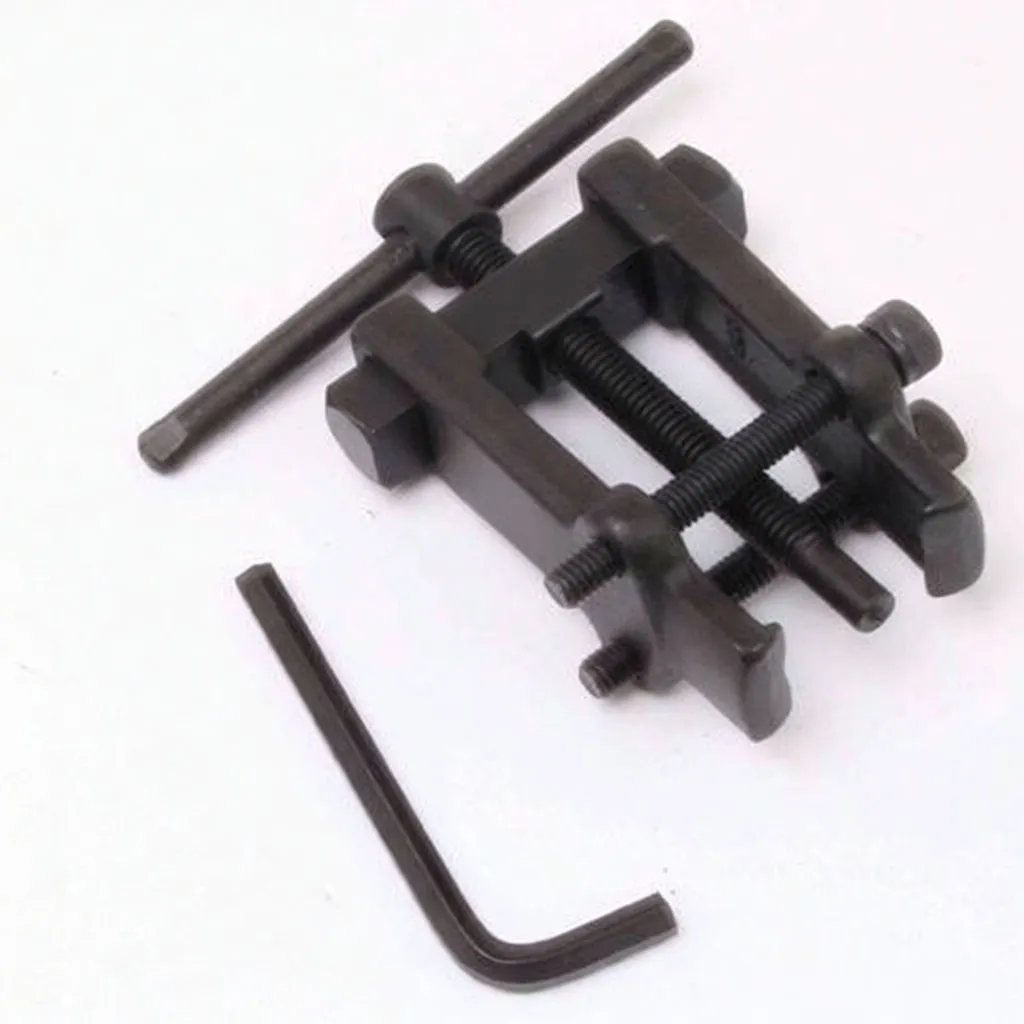 Top-down image of two-jaw puller with threaded forcing screw, sliding arms, T-handle and an L-shaped allen key; brand text on crossbar.