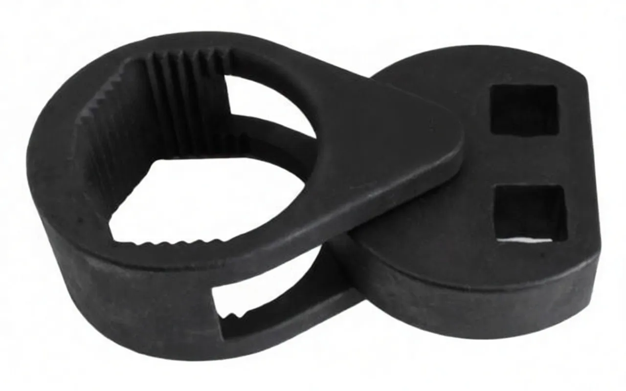 Three-quarter side view of the matte black master wrench showing serrated ring, pivot lever with ASTA A-27TW44 text, and round head with two square drive holes
