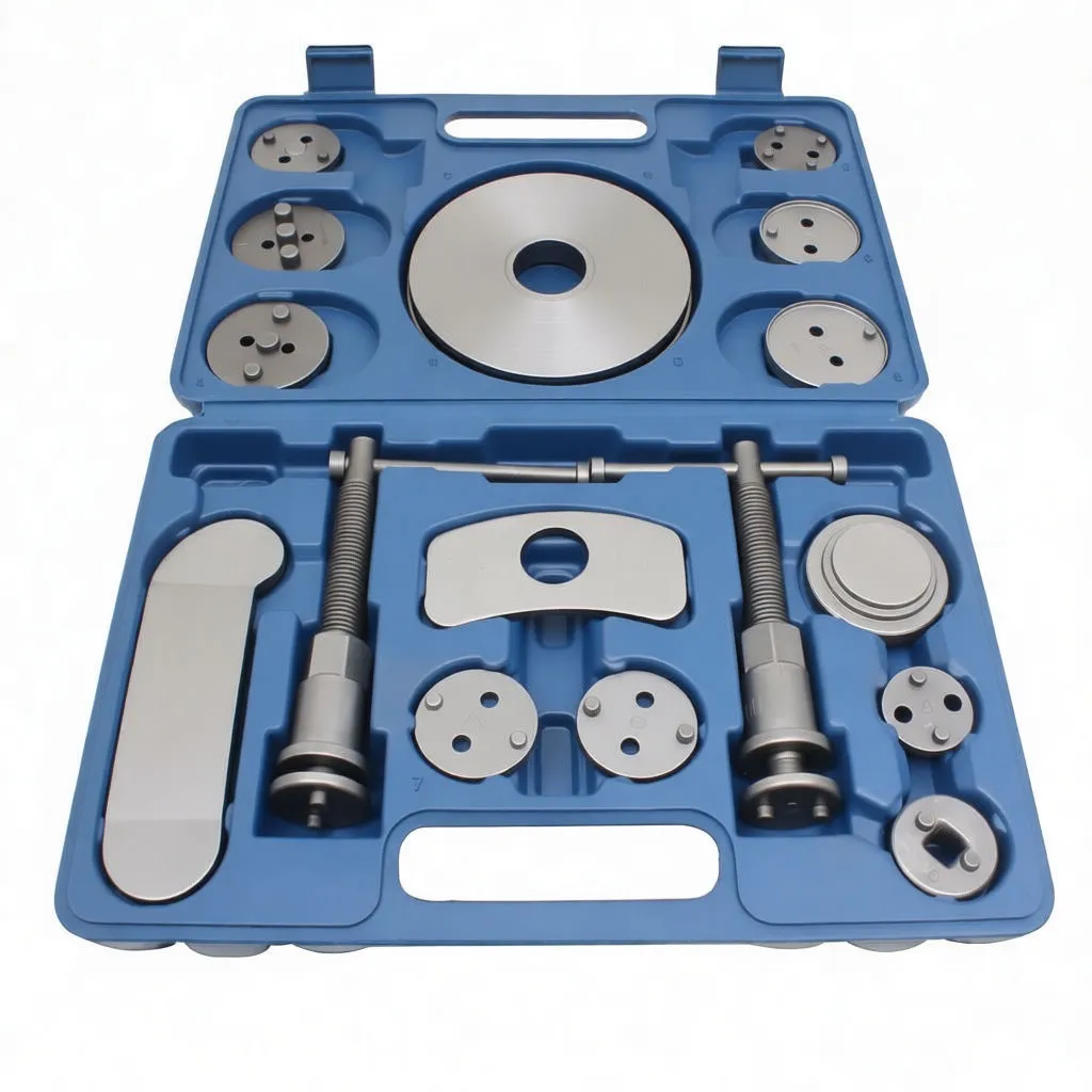 All parts from the caliper wind-back kit arranged on white background: two threaded retraction tools, a curved plate, a crescent spacer and many round adapter discs with various lug patterns.