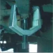 Pitman arm puller installed on steering component under a vehicle with central screw bearing on shaft