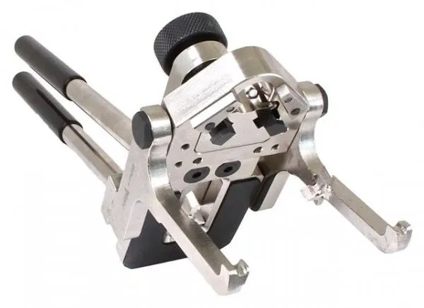 Rear close-up of valve spring installer showing machined head, locating holes, black spacer and forked jaws