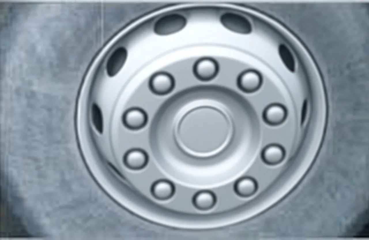 Vehicle wheel with a black wheel shaft cover/socket installed over the center hub, finger pointing at the cover